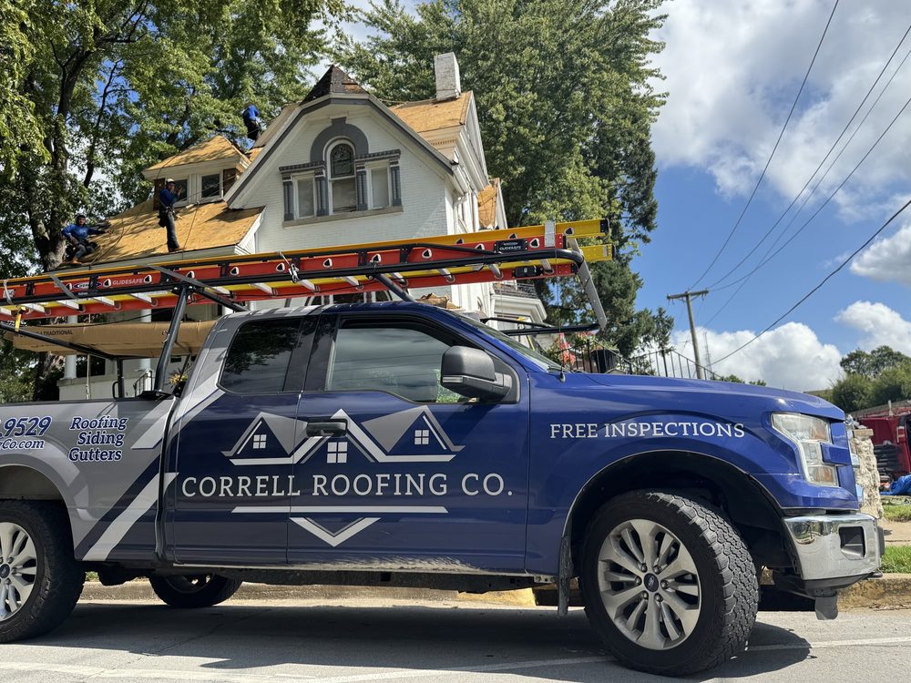 Blue Ford F-150 with ladder rack wrapped for Correll Roofing Co at a residential roofing job in progress