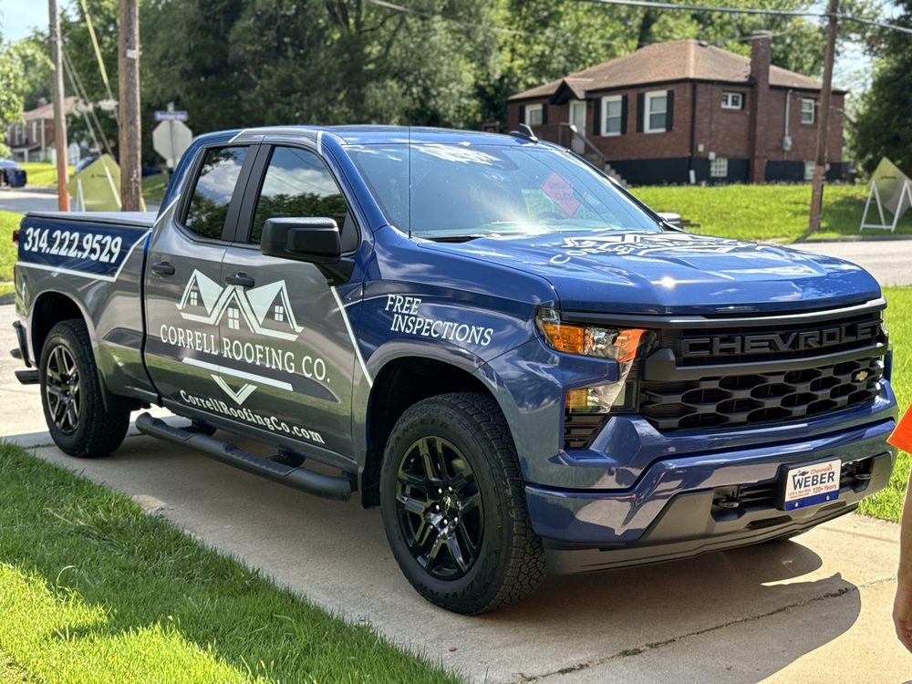 Blue Chevrolet Silverado wrapped for Correll Roofing Co with white and gray roof-line graphics and a free inspections offer